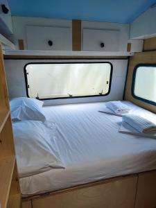 波尔托罗Hostel Trobenta in Oblak的船后方的一张带窗户的床