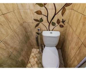 SukobumiKartini Guest House near Alun Alun Probolinggo的浴室设有卫生间,墙上挂着一棵树。