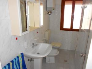 罗索利纳马雷Sabrina的白色的浴室设有水槽和卫生间。