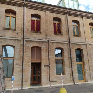 拉文纳affittacamere Corte Callegari的街上有多扇窗户的砖砌建筑