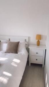 PerranwellDingley Dell - Superb location for Truro in private accommodation的一间白色卧室,配有床和床头柜