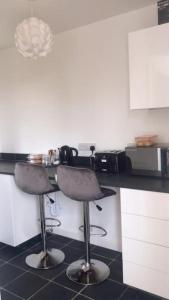 PerranwellDingley Dell - Superb location for Truro in private accommodation的厨房在柜台前设有两个吧台凳