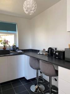 PerranwellDingley Dell - Superb location for Truro in private accommodation的厨房配有白色橱柜和黑色台面