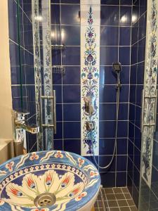 伊斯坦布尔Heristage Istanbul的蓝色瓷砖浴室设有水槽和淋浴