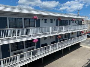 汉普顿Ways Motel的公寓大楼设有白色阳台和粉红色的鲜花