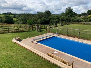 雷克瑟姆Little Pentre Barn with pool June - August的一个带围栏的院子内的游泳池