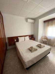 阿利坎特Cozy Apartment in Centre of Alicante near Plaza de Toros的一间卧室配有一张床,上面有两条毛巾