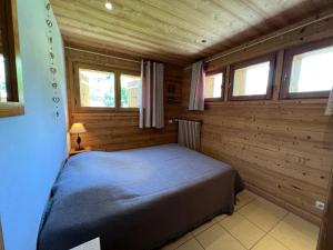 拉克吕萨Petit Lutin - Chalet sur les pistes的小木屋内一间卧室,配有一张床
