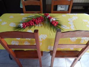 Pueu派佑村酒店的一张黄色桌子,上面有鲜花,还有两把椅子