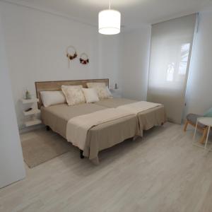 卢安科Tu Casina del Norte的一间白色客房内配有一张大床的卧室