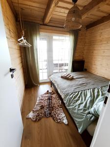 MiežonysChill House的木制客房内的一间卧室,配有一张床