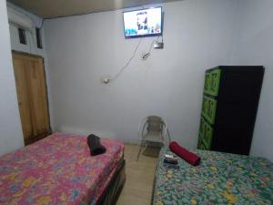 北加浪岸Hotel Near Ramayana 3的卧室配有一张床,墙上配有电视。