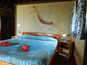 Pueu派佑村酒店的一间卧室,床上有两朵玫瑰