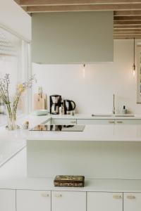 圣劳伦斯Huisje Nummer Tien的白色的厨房配有白色橱柜和水槽
