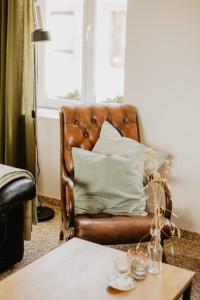 圣劳伦斯Huisje Nummer Tien的客厅里一张棕色的皮沙发,配有桌子