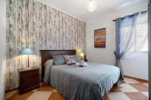 加的斯Descanso en Cádiz的一间卧室配有一张床、一个梳妆台和一扇窗户。