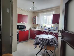 格但斯克Olaf Apart的厨房配有红色橱柜和带桌布的桌子