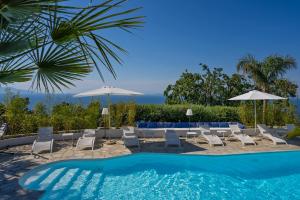 阿纳卡普里Capri Blue Luxury Villa Le Tre Monelle的一个带椅子和遮阳伞的游泳池