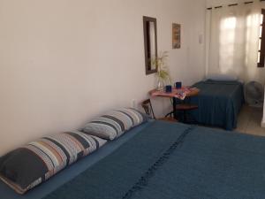 戈亚斯州上帕莱索A Taberna - chalés的一间卧室,床上配有两个枕头,一张桌子