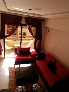 马拉喀什Agréable appartement au coeur de Guéliz, Marrakech的客厅配有红色沙发和红色椅子