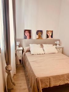 奥洛特Precioso piso en el centro neurálgico de Olot的卧室配有一张墙上三幅照片的床