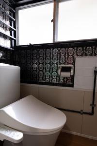冈山Unique joy House的一间带白色卫生间的浴室和窗户。