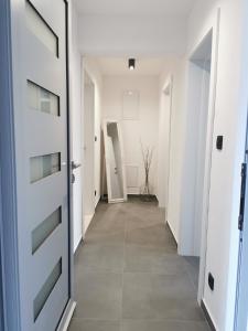 科尔丘拉Guesthouse Korkyra Sun的走廊设有白色门,铺有瓷砖地板