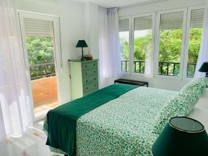 格拉纳达FAISÁN 20 Apartamento的一间卧室配有一张带绿色床罩的床和窗户