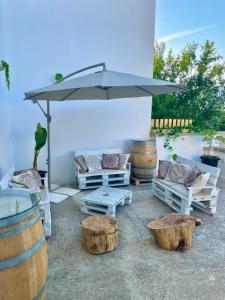 波贾尔多L'ANTICA PIETRA Casa Vacanza Salento的庭院配有桌椅和遮阳伞。
