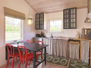 吉利勒杰6 person holiday home in Dronningm lle的厨房配有桌子和一些红色的椅子