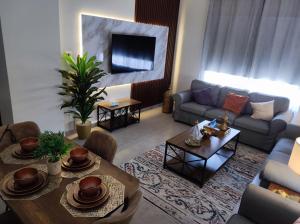 阿卜杜勒国王经济城العبير شقة فندقية的客厅配有沙发和桌子
