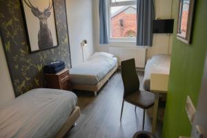 格罗宁根Simplon Hostel的客房设有两张床、一把椅子和窗户。