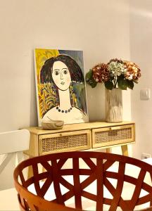 奥洛特Precioso piso en el centro neurálgico de Olot的一张桌子上一幅带椅子的女人画