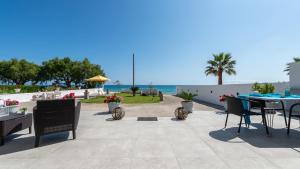 阿利卡纳斯Vrachos holiday home的一个带桌椅的庭院和大海