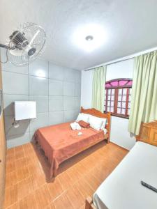 雅库廷加河畔圣丽塔Pousada Iasbeck的一间卧室配有一张带风扇和窗户的床。