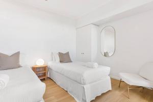 马库拉Fresh Beautifully Styled 2 BR Resort Apt at Marcoola的一间白色卧室,配有两张床和镜子