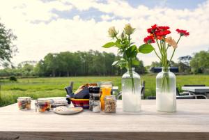 斯霍尔Villa de Hazelaar的一张桌子上放着两瓶花和鲜花
