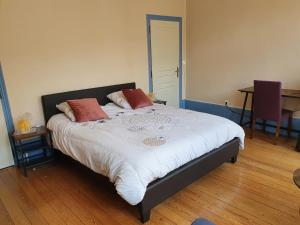 Mareuil-sur-AyLa Cour des Marotiers的一间卧室配有一张大床和两个枕头