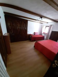 努斯Casa Elena的一间卧室设有两张红色的床和窗户