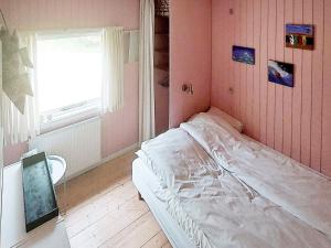 维斯特索马肯Two-Bedroom Holiday home in Aakirkeby 7的一间小卧室,配有床和窗户