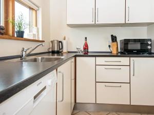 托斯明德8 person holiday home in Ulfborg的厨房配有白色橱柜和水槽
