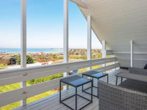 猎枪海滩7 person holiday home in Knebel的阳台配有2张桌子和椅子,享有海景。