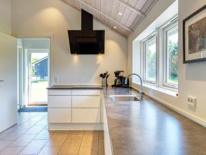 博托比Holiday Home Hansavej的厨房配有白色橱柜、水槽和窗户。