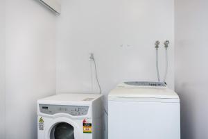 奥克兰Self Contained Cottage Pukekohe的客房内的洗衣机和洗衣机