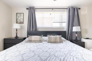 费尔维尤帕克Georgetown Villas 2-1c King and Queen Bedrooms ideal for long stays!的一间卧室配有一张带两盏灯的大型白色床。