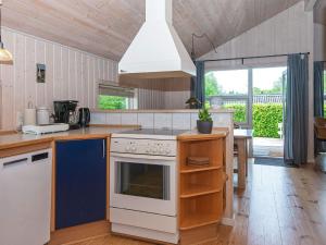 锡尔克堡Holiday home Silkeborg XIX的一间带炉灶的厨房 桌子旁的顶部烤箱