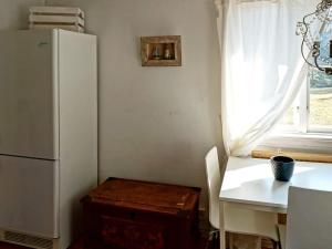 特鲁萨Holiday home TROSA的厨房配有白色冰箱、桌子和窗户