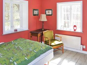 VankivaHoliday home VANKIVA的一间卧室配有一张床、一把椅子和窗户。