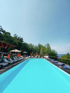 法拉尔雅Rocas Roja Beach Hotel Faralya的一个带椅子和遮阳伞的大型游泳池