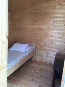 科林基拉Koli caravan cottages的小房间,木墙里设有一张床